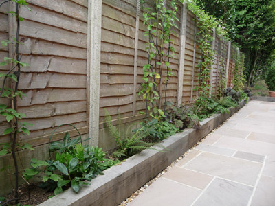Design ideas for a large modern side fully shaded garden in Sussex with a garden path and natural stone paving.