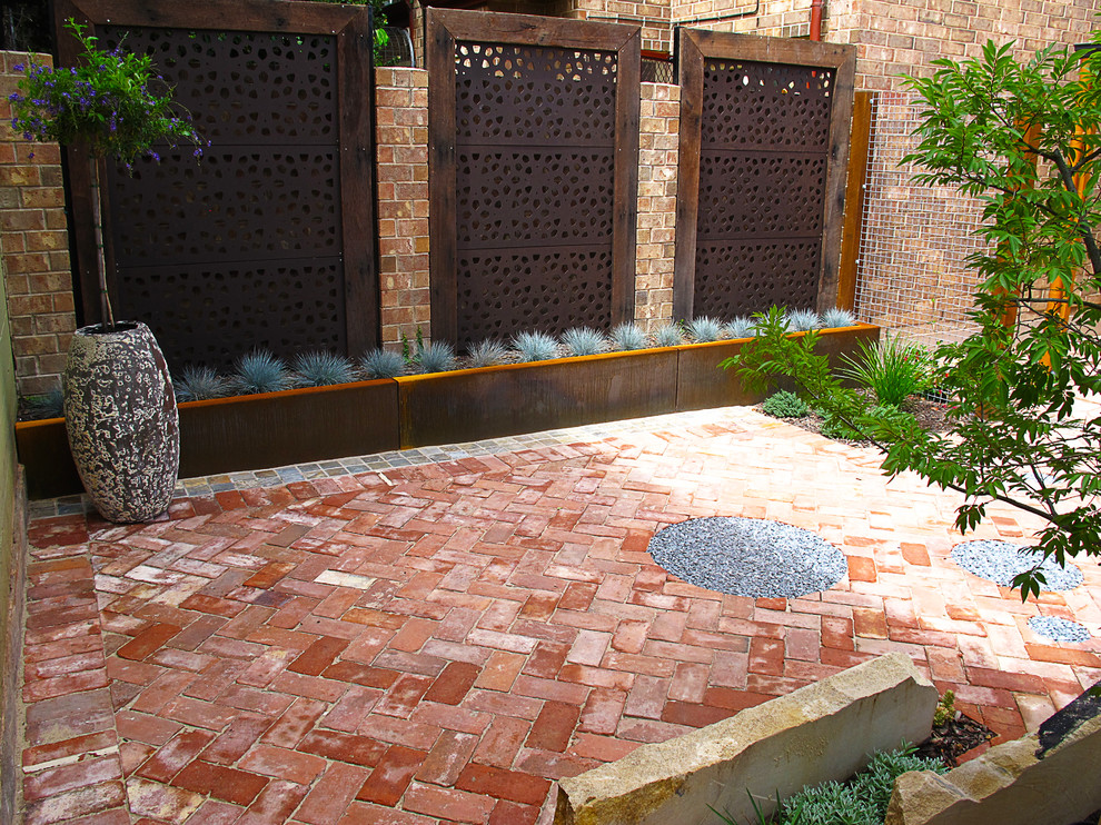 Idee per un piccolo giardino formale bohémian dietro casa con pavimentazioni in mattoni