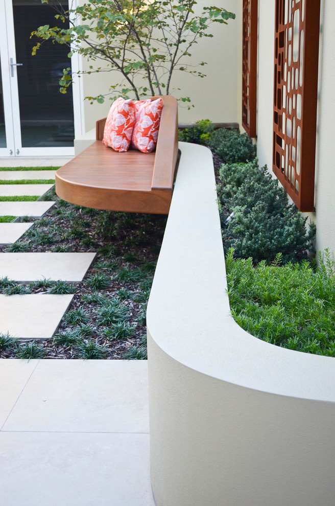 Idee per un giardino moderno esposto a mezz'ombra di medie dimensioni e in cortile con pavimentazioni in cemento