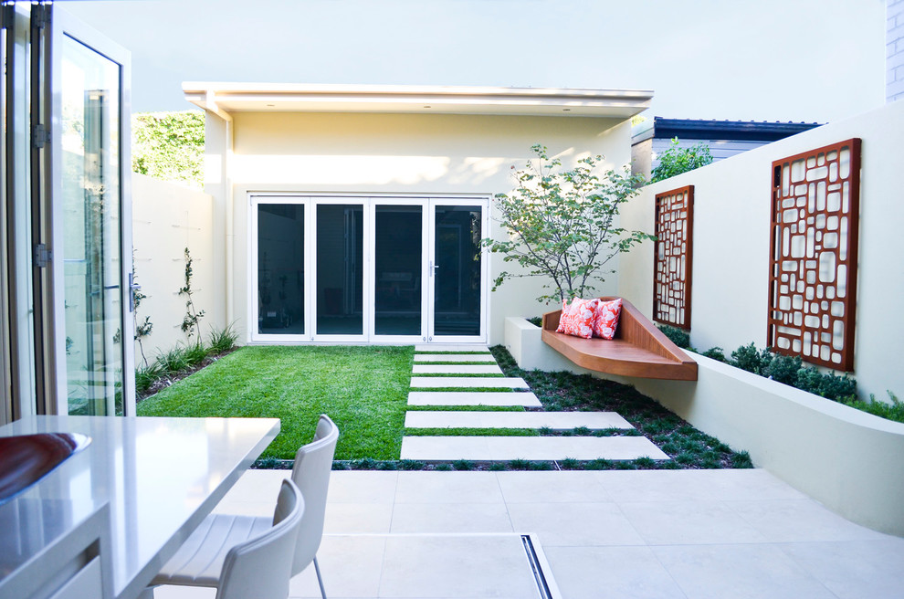 Esempio di un giardino minimalista esposto a mezz'ombra di medie dimensioni e in cortile con pavimentazioni in cemento
