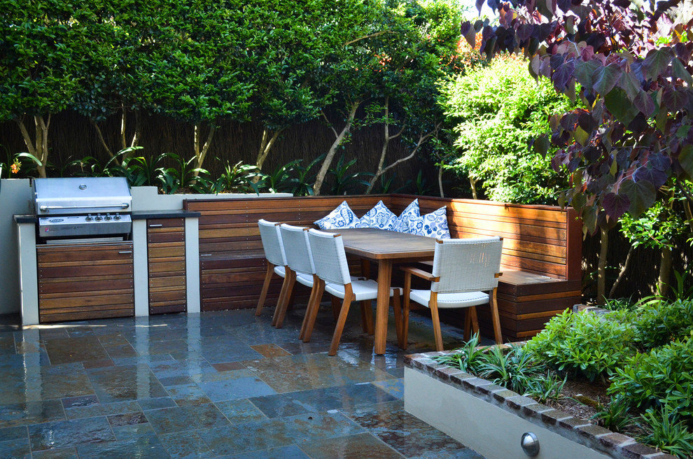 Inspiration for a mid-sized modern partial sun backyard stone landscaping in Sydney.