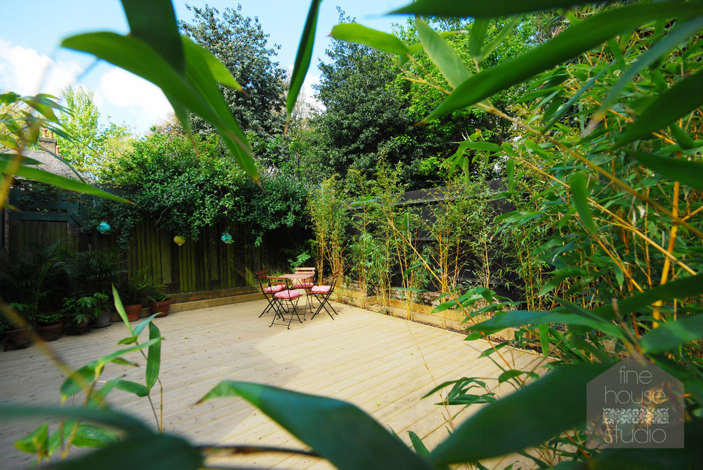 Imagen de jardín actual de tamaño medio en verano en patio trasero con jardín de macetas, exposición parcial al sol y entablado