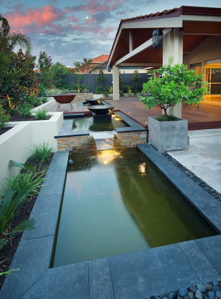 Cette photo montre un jardin arrière tendance avec un point d'eau et une terrasse en bois.