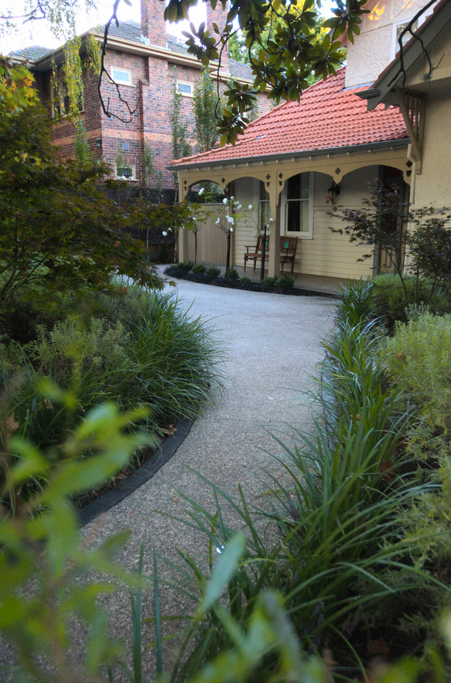 Diseño de jardín campestre de tamaño medio en patio delantero con jardín francés y adoquines de piedra natural