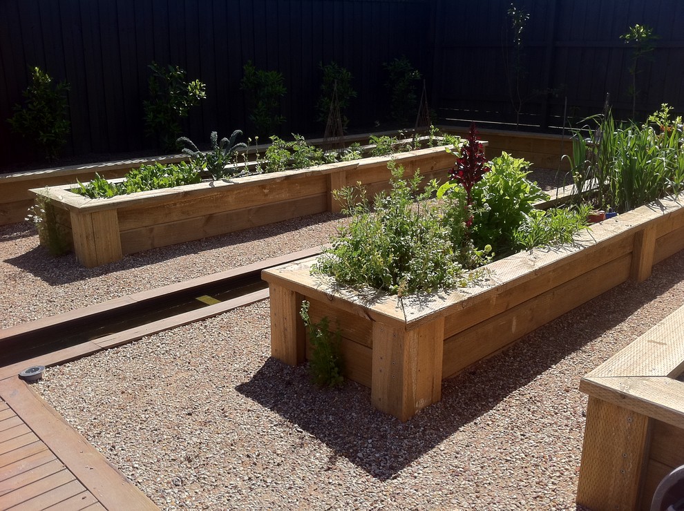Idée de décoration pour un jardin potager tradition avec une terrasse en bois.