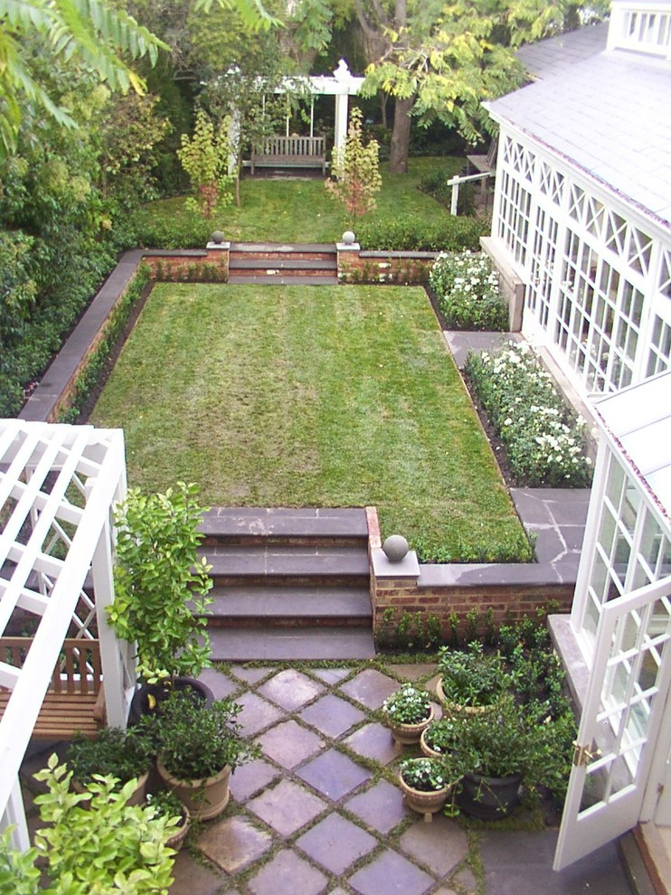 Geometrischer Klassischer Garten hinter dem Haus mit Natursteinplatten und Rasenkanten in Melbourne
