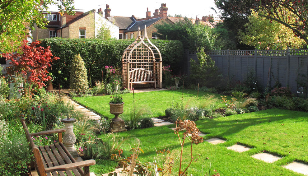 На фото: летний регулярный сад среднего размера на заднем дворе в классическом стиле с садовой дорожкой или калиткой и мощением тротуарной плиткой