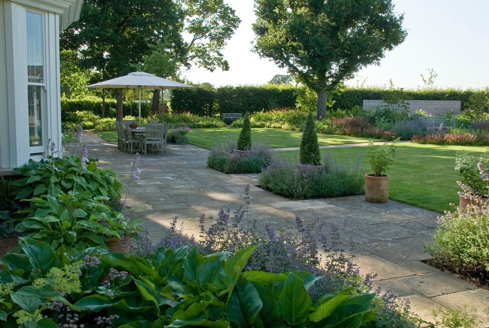 Idées déco pour un grand jardin à la française arrière victorien l'été avec une exposition partiellement ombragée et des pavés en pierre naturelle.