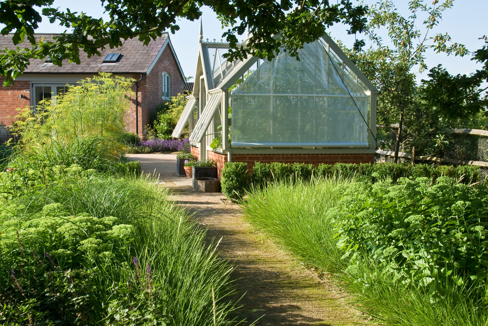 Inspiration pour un grand jardin arrière victorien l'été avec une exposition partiellement ombragée et des pavés en pierre naturelle.
