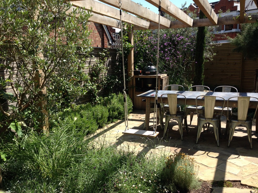 Imagen de jardín de estilo de casa de campo de tamaño medio en verano en patio trasero con jardín francés, jardín vertical, exposición parcial al sol y adoquines de hormigón