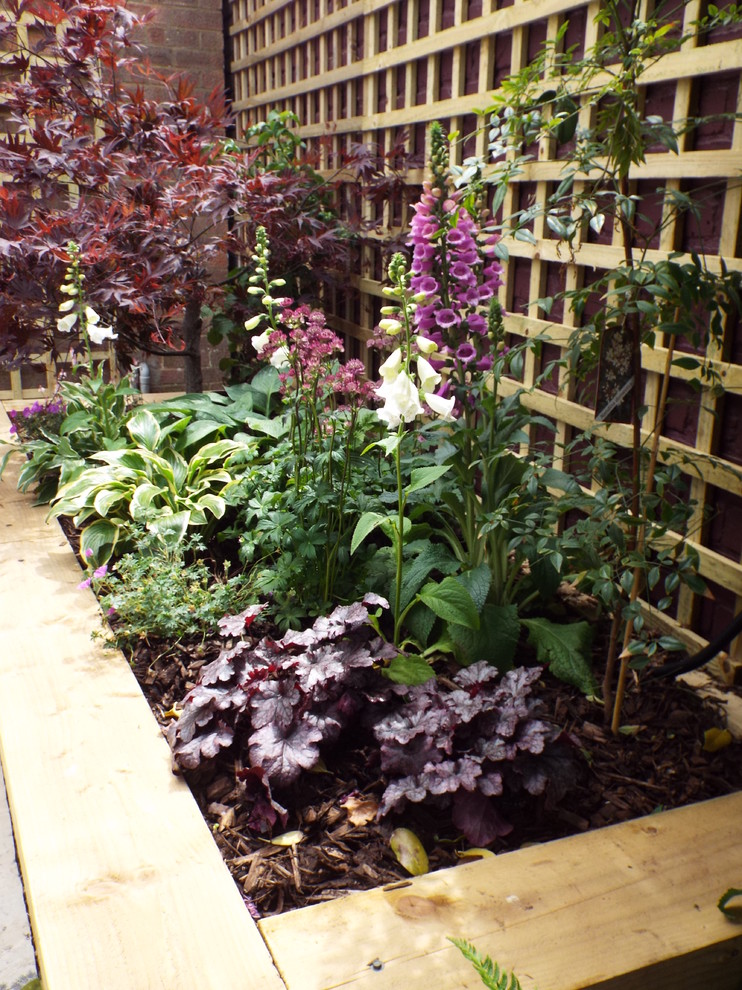 Cette image montre un petit jardin sur cour design avec une exposition partiellement ombragée et des pavés en pierre naturelle.