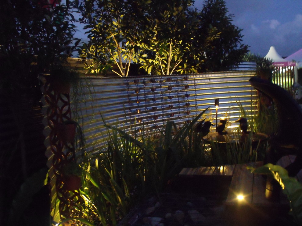 На фото: солнечный, весенний садовый фонтан среднего размера на переднем дворе в стиле неоклассика (современная классика) с хорошей освещенностью и мульчированием