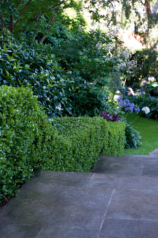 Foto de jardín tradicional grande en primavera en patio delantero con jardín francés, exposición reducida al sol y adoquines de piedra natural