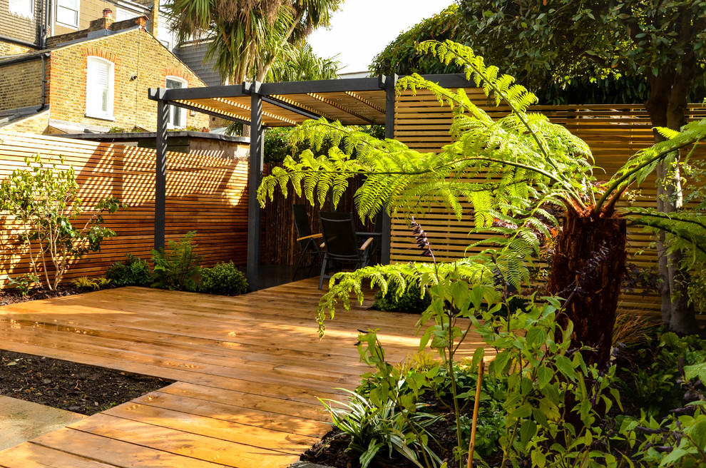 Aménagement d'un petit jardin arrière contemporain avec une exposition partiellement ombragée et une terrasse en bois.
