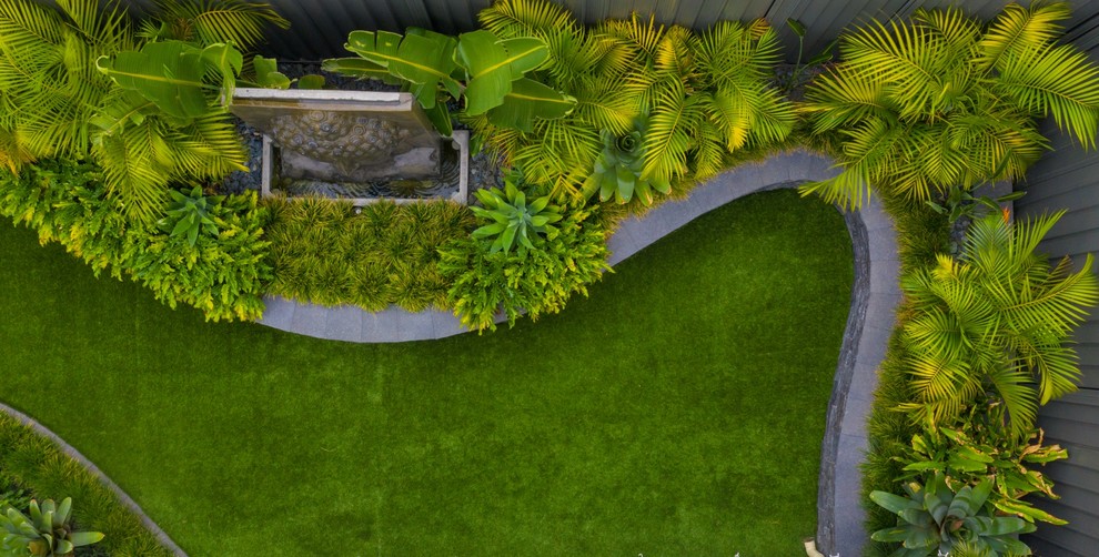 На фото: летний регулярный сад среднего размера на заднем дворе в морском стиле с подпорной стенкой, полуденной тенью и покрытием из каменной брусчатки