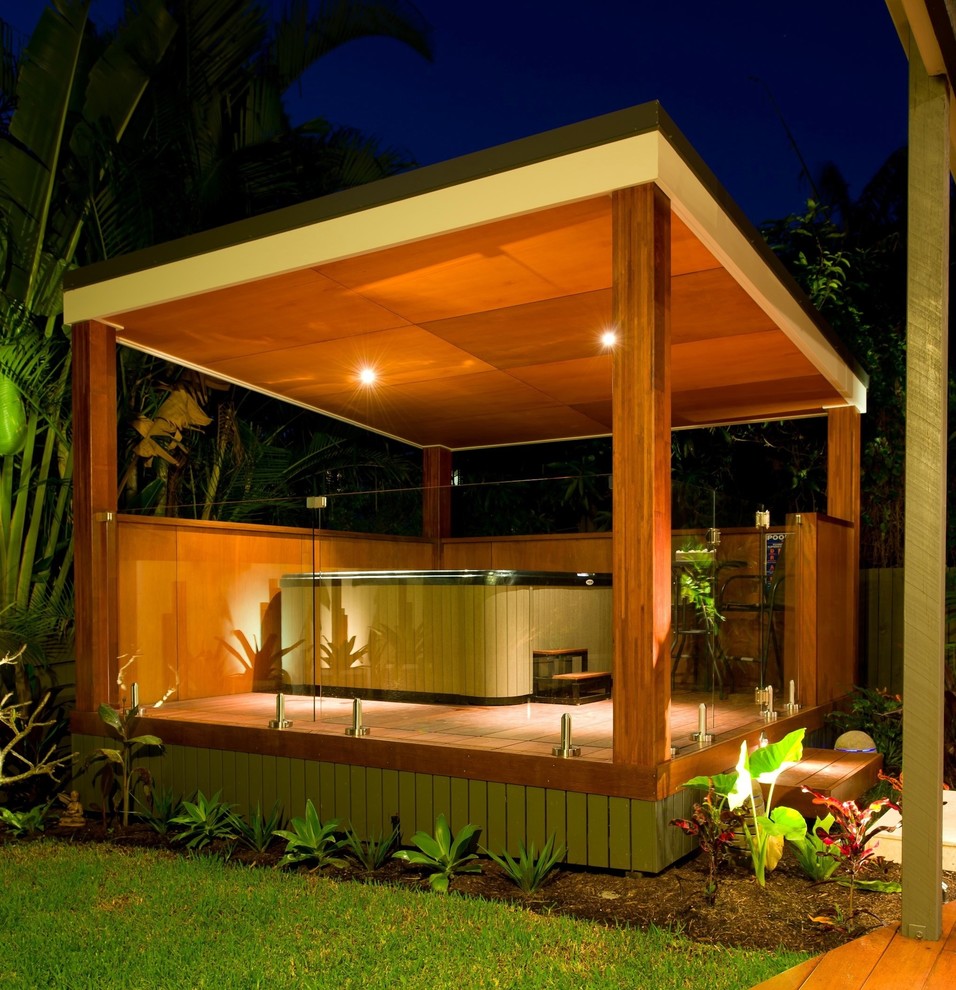 Design ideas for a mid-sized tropical backyard landscaping in Brisbane with decking.