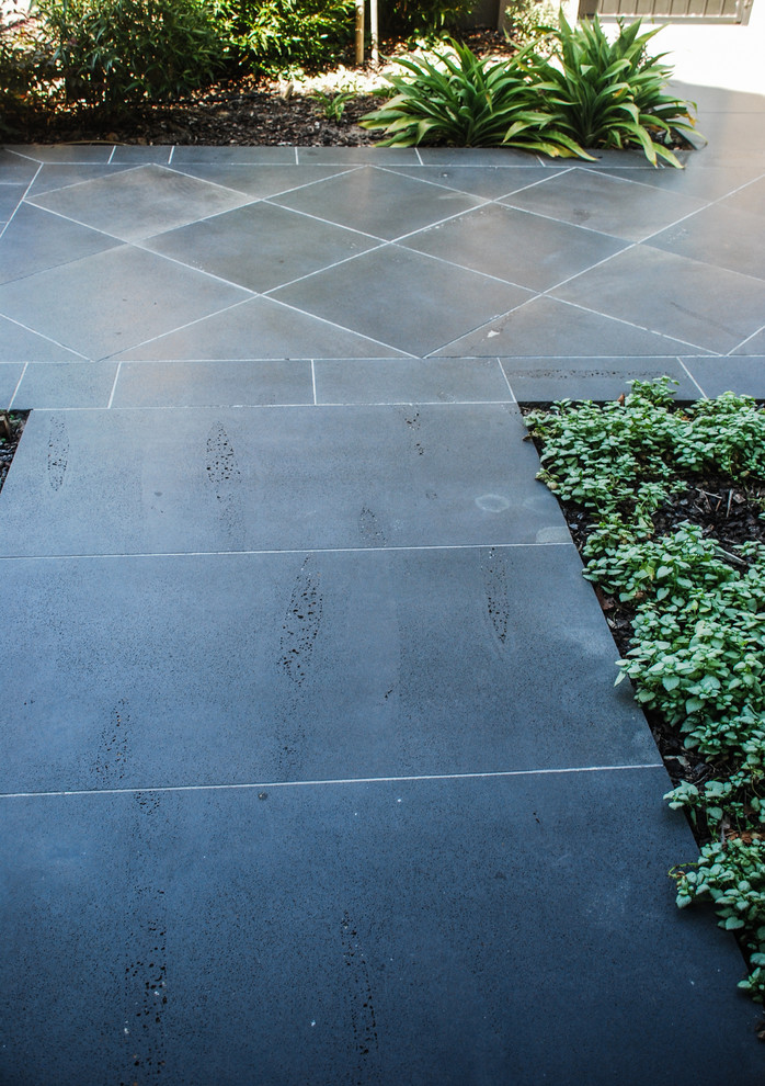 Immagine di un giardino formale minimal esposto a mezz'ombra di medie dimensioni e davanti casa con pavimentazioni in pietra naturale