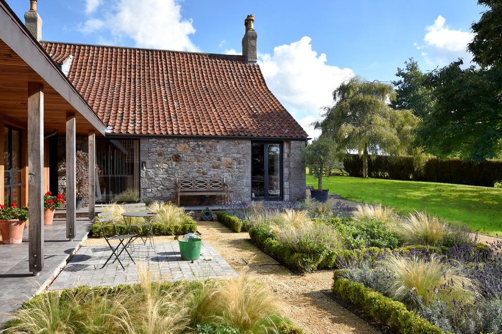 Idée de décoration pour un jardin à la française champêtre avec une exposition ensoleillée et des pavés en pierre naturelle.