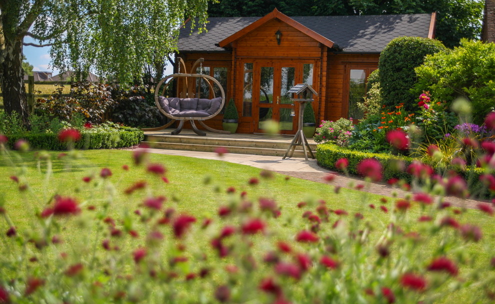 На фото: большой солнечный, летний регулярный сад на заднем дворе в стиле кантри с хорошей освещенностью и мощением клинкерной брусчаткой