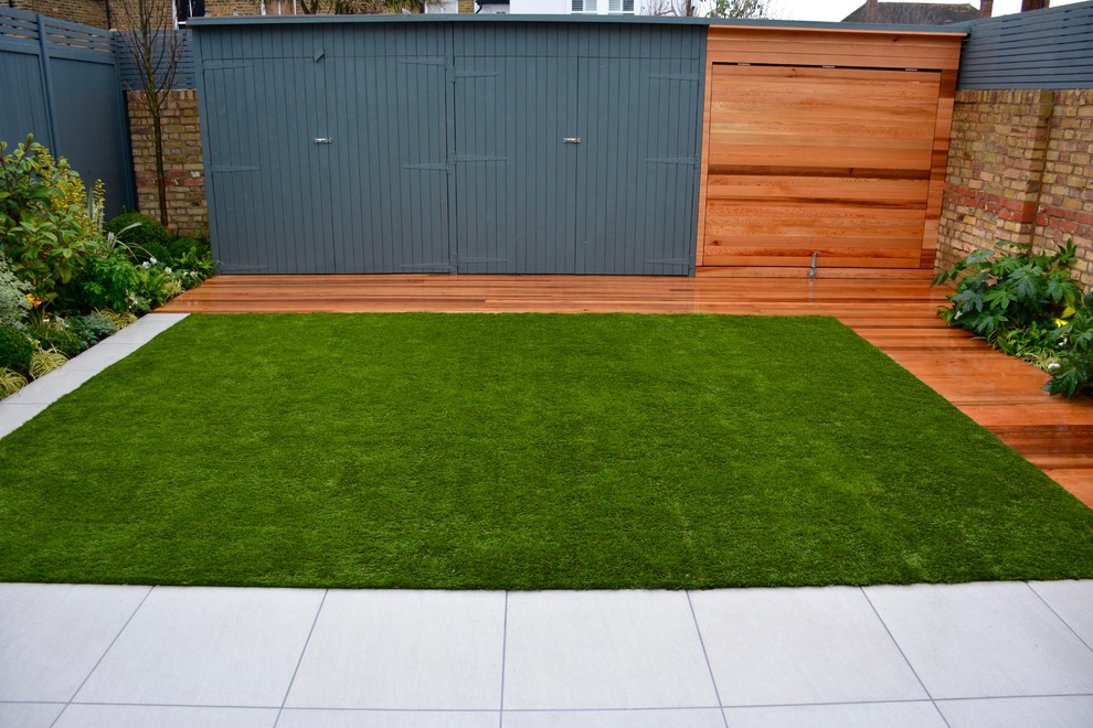This is an example of a medium sized contemporary back partial sun garden in London with decking.