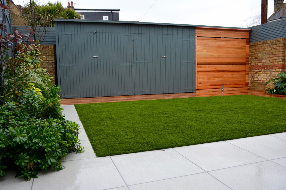 Design ideas for a mid-sized contemporary partial sun backyard landscaping in London with decking.