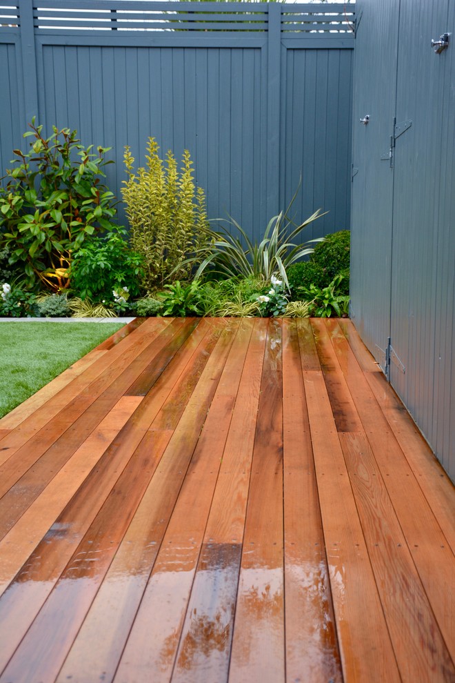 This is an example of a medium sized contemporary back partial sun garden in London with decking.