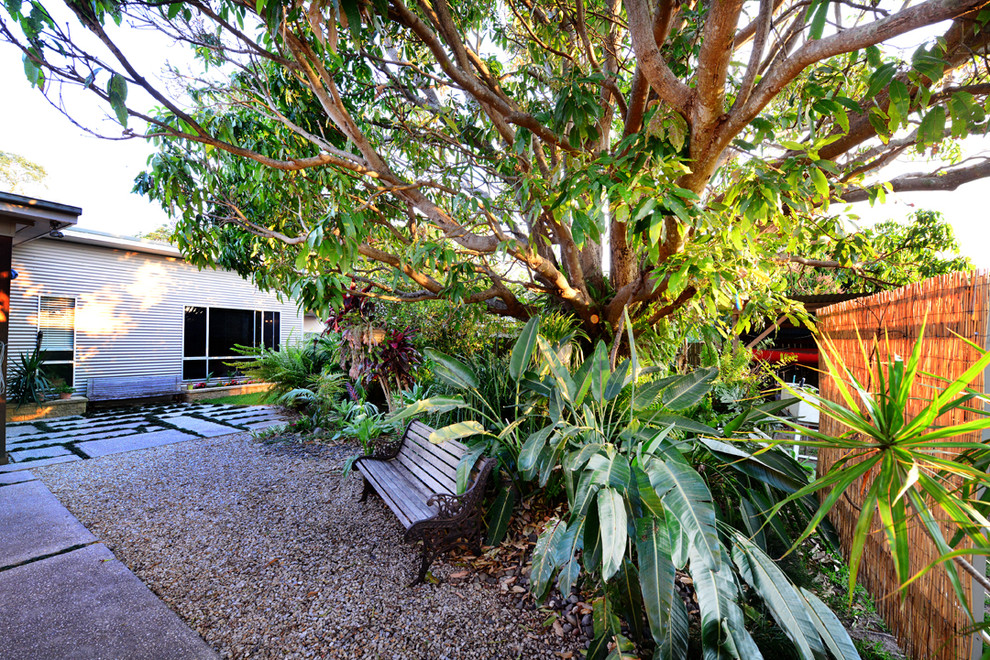 Diseño de jardín moderno grande en patio delantero con jardín francés y gravilla