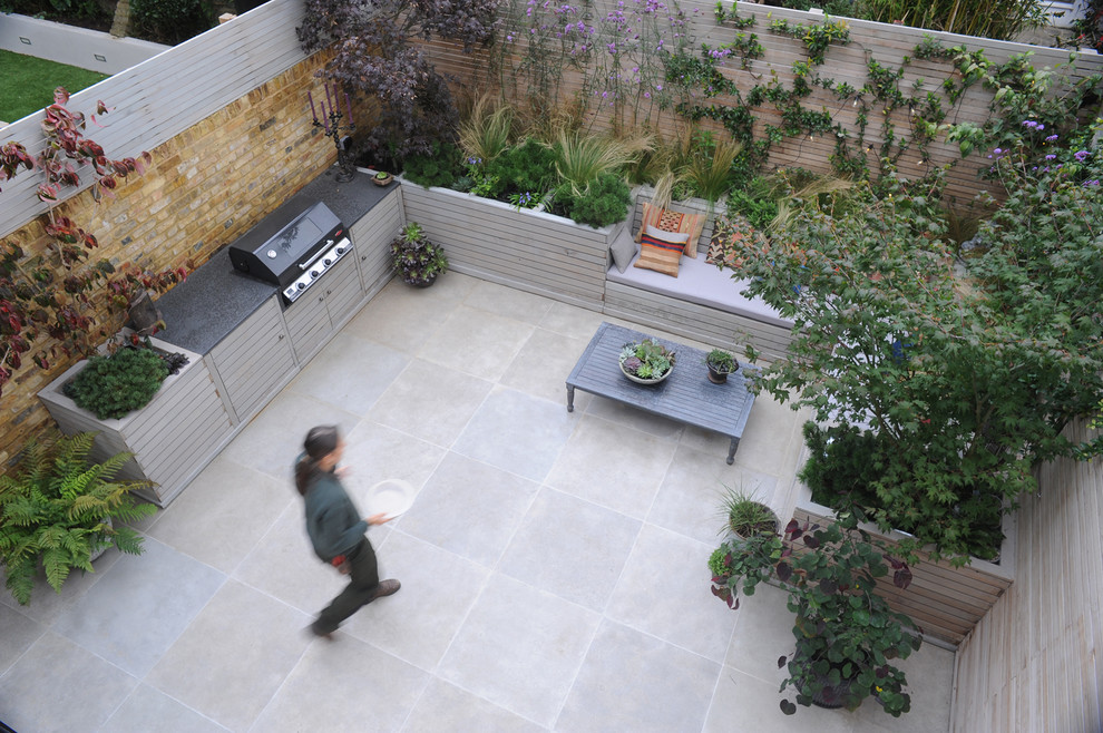 Immagine di un patio o portico bohémian dietro casa con un giardino in vaso e pavimentazioni in pietra naturale