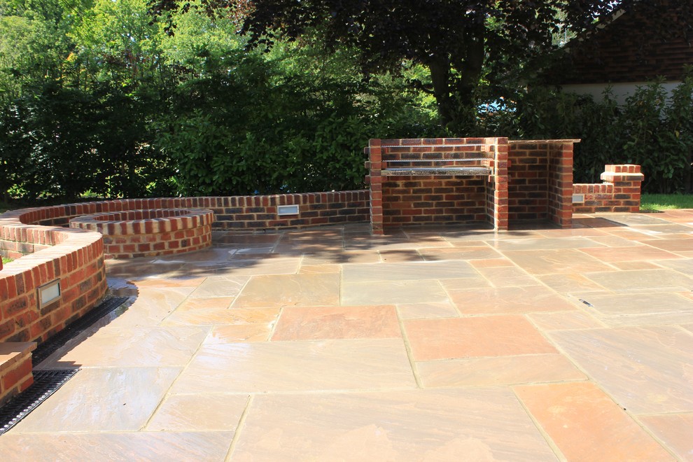 Large traditional back garden in Surrey with natural stone paving.