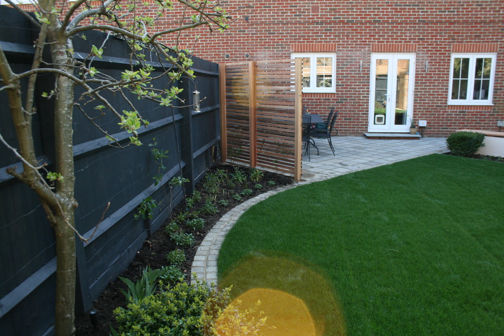 Inspiration for a small contemporary partial sun backyard stone landscaping in Oxfordshire with a fire pit for spring.