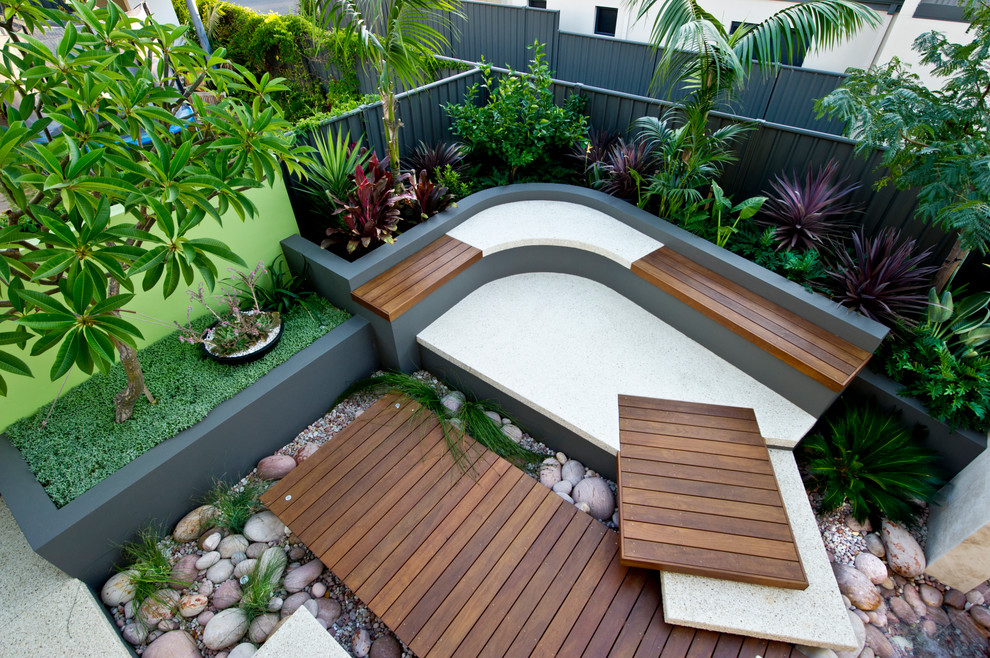 Réalisation d'un jardin arrière design de taille moyenne avec un bassin, une exposition ensoleillée et une terrasse en bois.