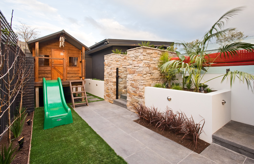 Стильный дизайн: большой участок и сад на заднем дворе в современном стиле с покрытием из каменной брусчатки и забором - последний тренд