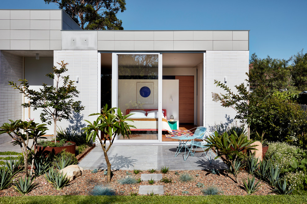 Ejemplo de jardín moderno de tamaño medio en patio trasero con adoquines de hormigón y exposición total al sol