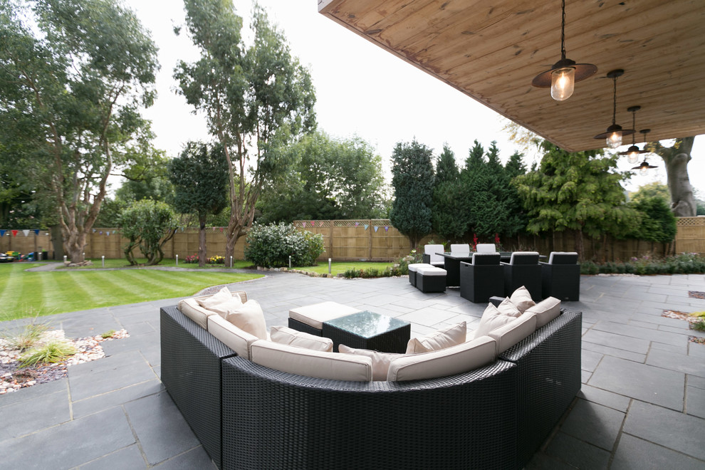 Immagine di un grande giardino moderno esposto a mezz'ombra dietro casa in estate con pavimentazioni in pietra naturale