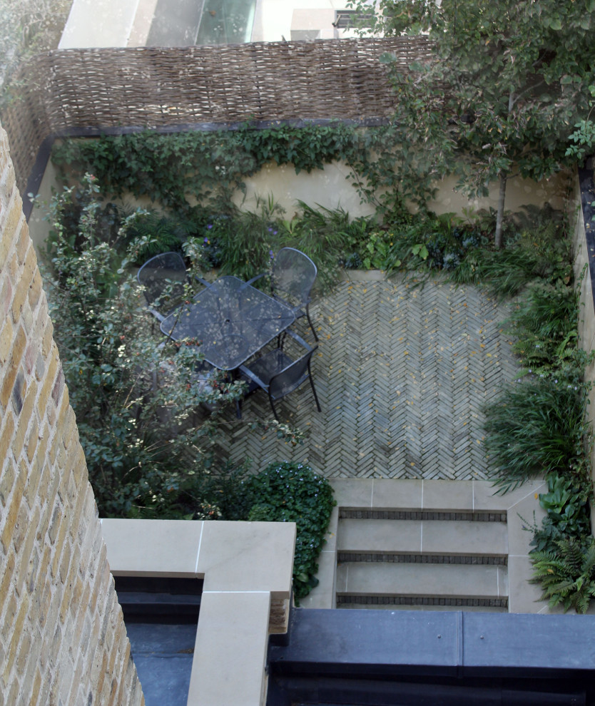 Design ideas for a small contemporary courtyard formal and private partial sun garden for autumn in London with brick paving.