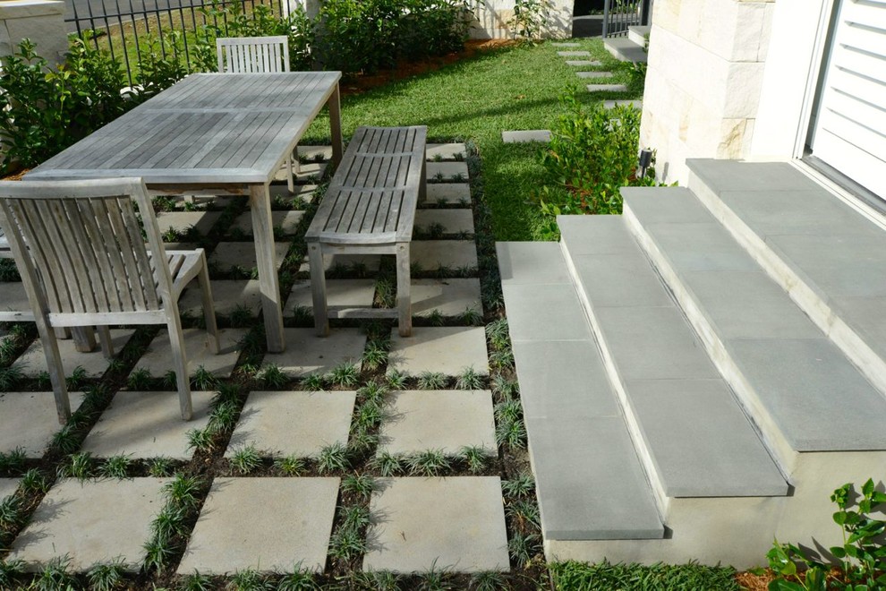 Diseño de jardín moderno con exposición total al sol y adoquines de hormigón