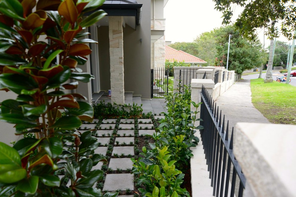 Cette image montre un jardin minimaliste avec une exposition ensoleillée et des pavés en béton.