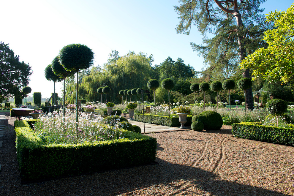 Foto di un ampio giardino formale minimal esposto in pieno sole dietro casa in estate con un ingresso o sentiero e ghiaia