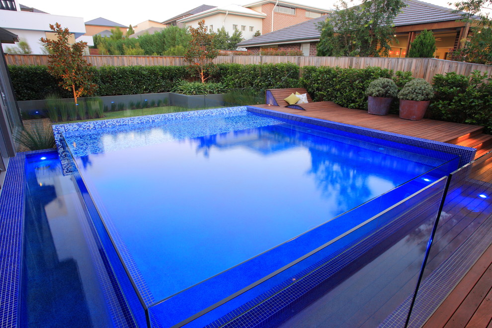 Exemple d'une piscine arrière tendance de taille moyenne avec un point d'eau et une terrasse en bois.
