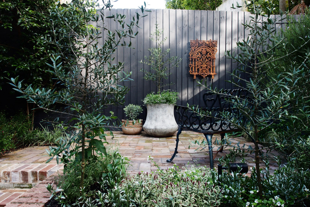 Modelo de jardín rústico pequeño en primavera en patio con exposición parcial al sol y adoquines de ladrillo