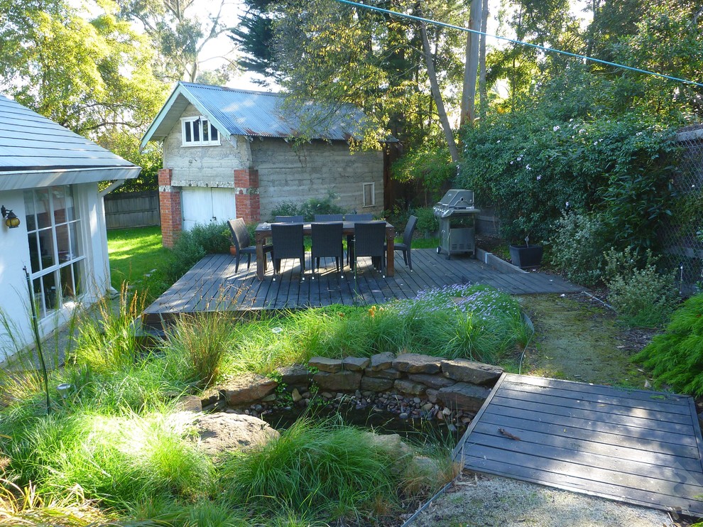 На фото: участок и сад в современном стиле с настилом и забором с