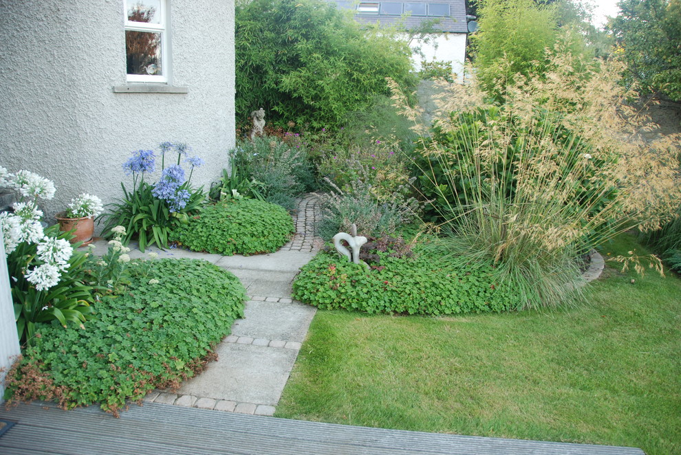 Mittelgroßer Klassischer Garten hinter dem Haus mit direkter Sonneneinstrahlung und Natursteinplatten in Dublin