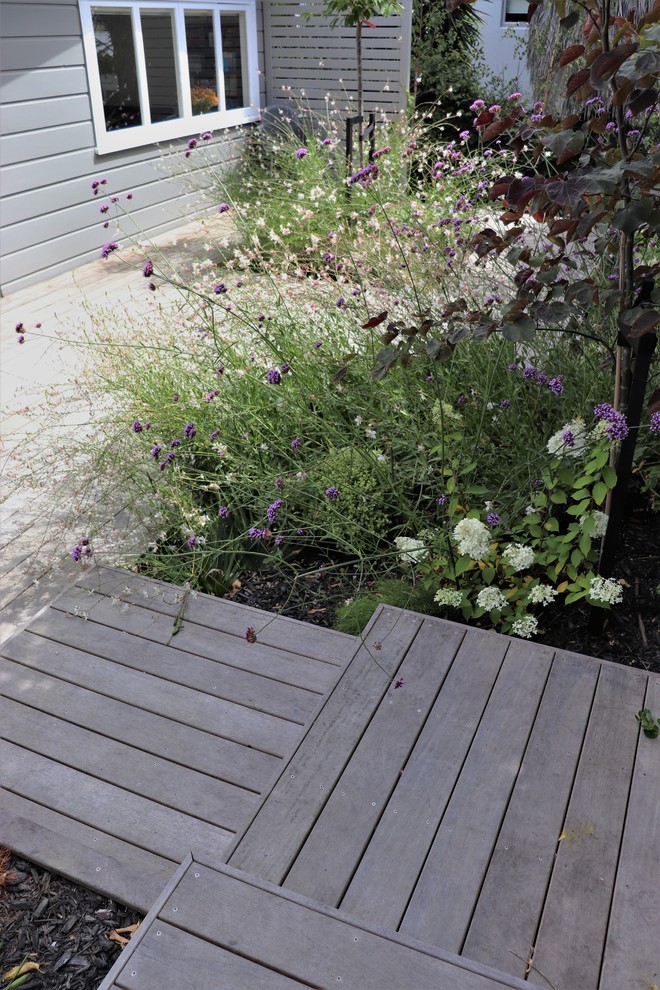 Пример оригинального дизайна: маленький летний участок и сад на заднем дворе в современном стиле с полуденной тенью и настилом для на участке и в саду