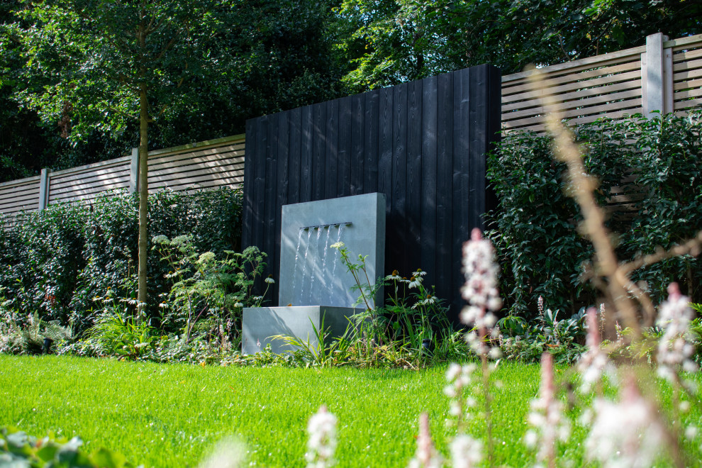 Immagine di un giardino moderno esposto in pieno sole di medie dimensioni e dietro casa in estate con pavimentazioni in pietra naturale