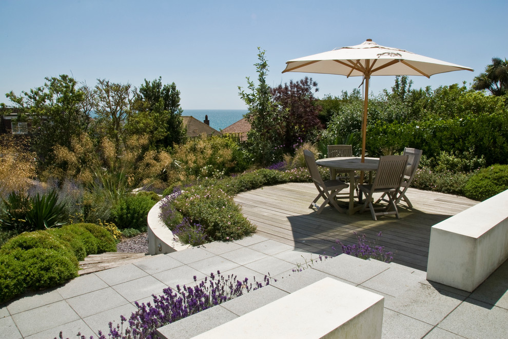 Idee per un giardino stile marinaro esposto in pieno sole di medie dimensioni e dietro casa in estate con un muro di contenimento e pavimentazioni in pietra naturale