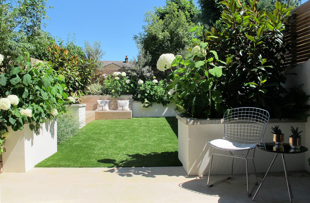 Kleiner Moderner Garten im Sommer, hinter dem Haus mit direkter Sonneneinstrahlung und Natursteinplatten in London