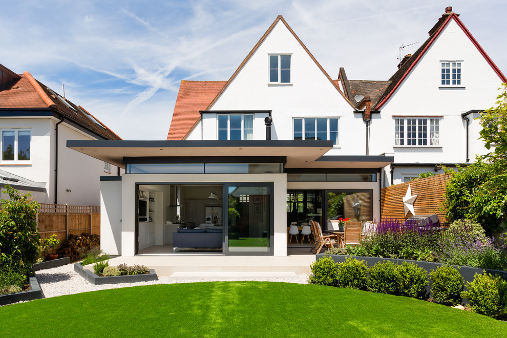 Contemporary back full sun garden in London with a retaining wall.