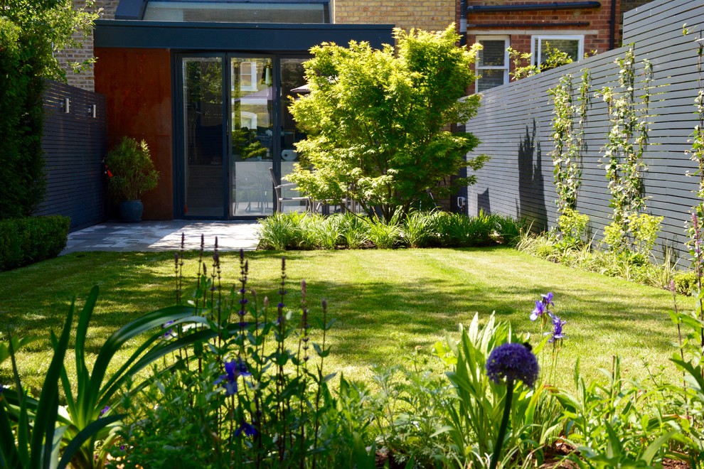 Photo of a medium sized contemporary back partial sun garden for summer in London with a pond.