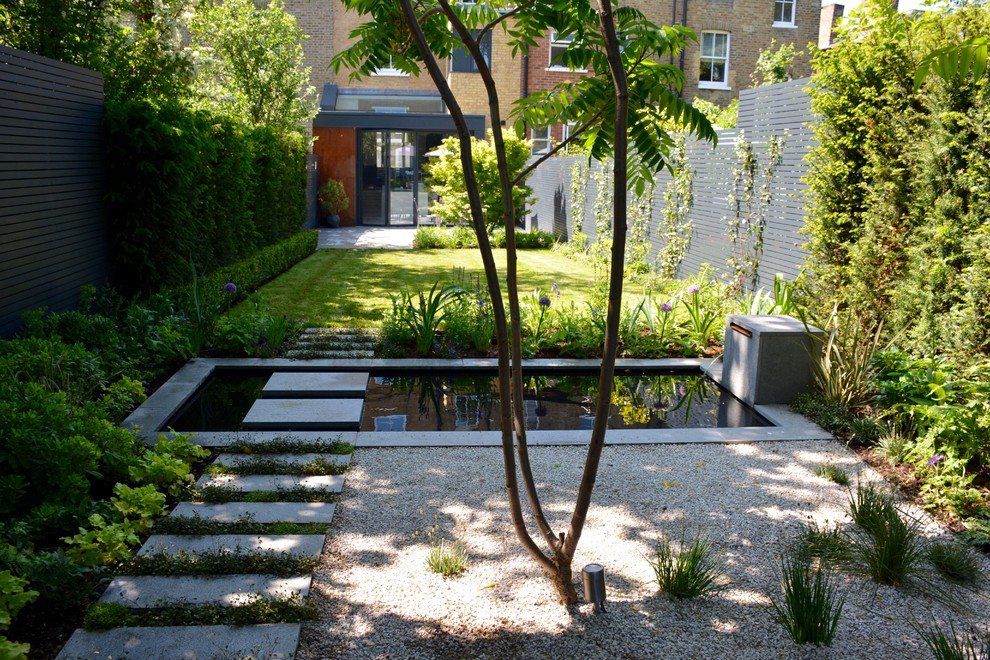 This is an example of a medium sized contemporary back partial sun garden for summer in London with a pond.