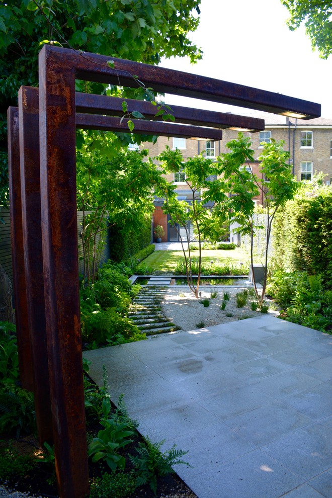Design ideas for a medium sized contemporary back partial sun garden for summer in London with a pond.